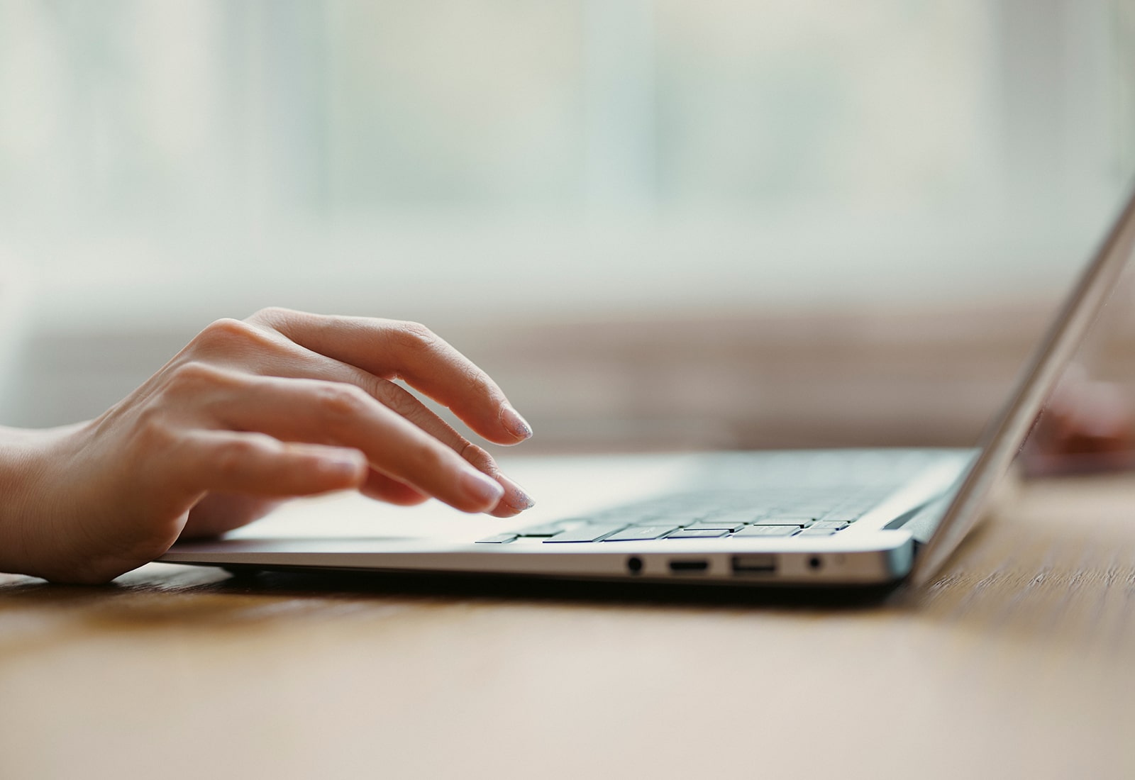 woman's hands crafting website copywriting on a laptop